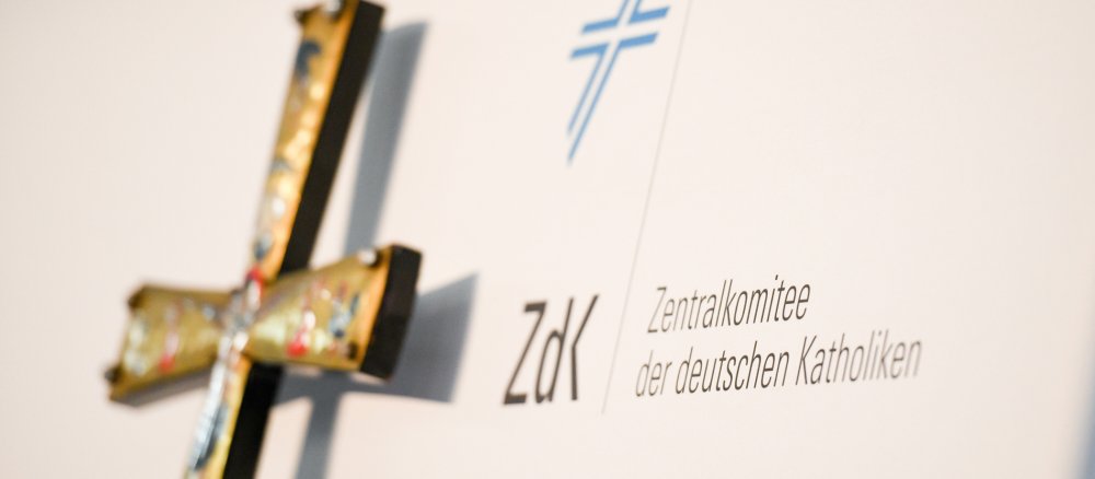 Ein Kreuz vor einer Leinwand mit dem Logo des ZdK