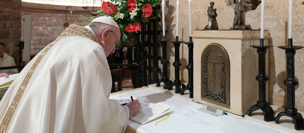Der Papst schreibt seine Unterschrift in ein Heft