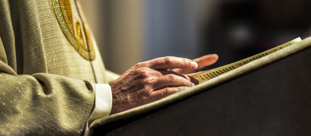 Ein Priester liest in der Bibel.