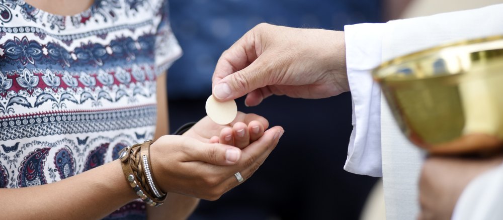 Eine Frau empfängt die Eucharistie