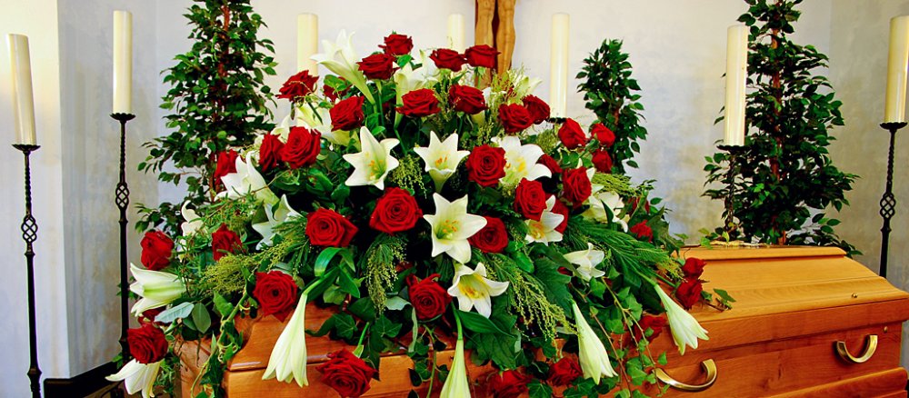 Ein mit Blumen geschmückter Sarg ist in der Begräbniskapelle aufgestellt
