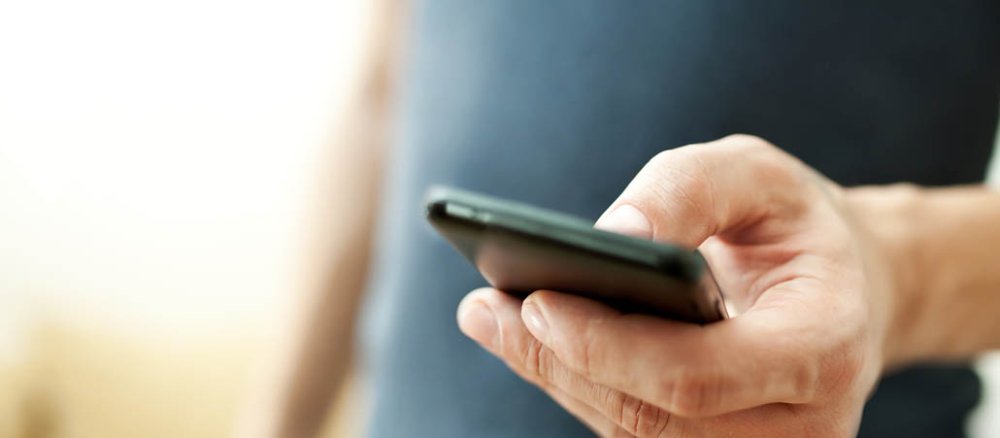 Ein Mann tippt auf seinem Smartphone.