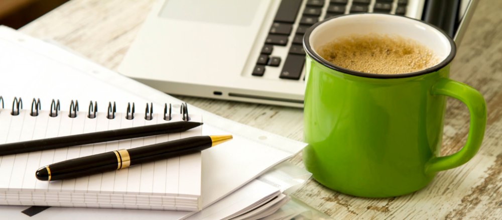 Schreibtisch mit Kaffeetasse, Laptop, Papier