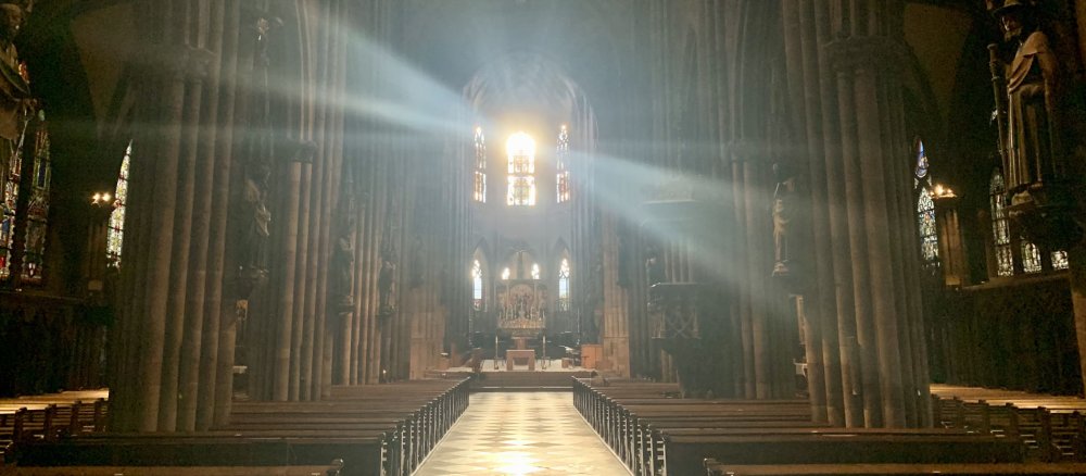 Die aufgehende Sonne scheint ins Innere des Freiburger Münster