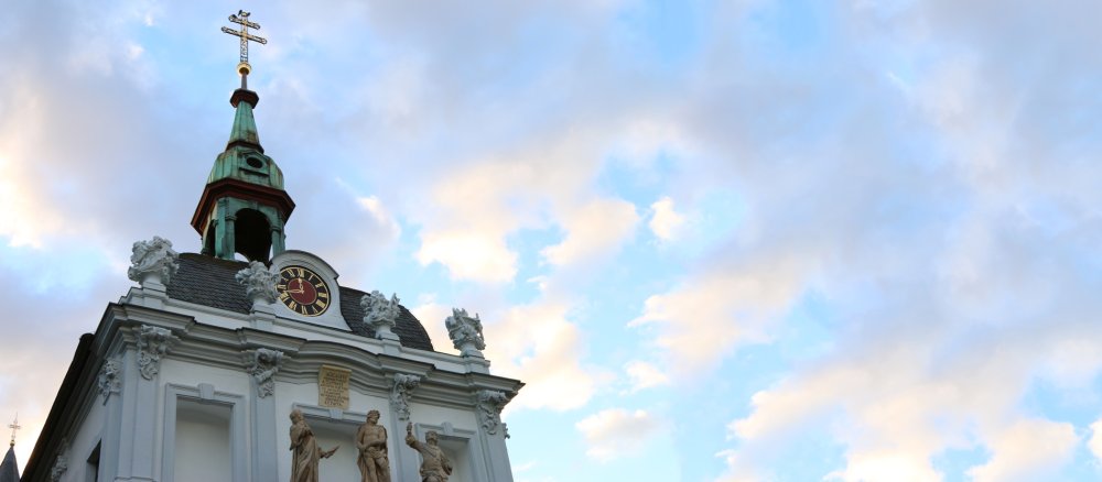 Eine Gruppe Statuen unter einer Scheinuhr zeigt, wie Pontius Pilatus das Todesurteil gegen Jesus fällt.