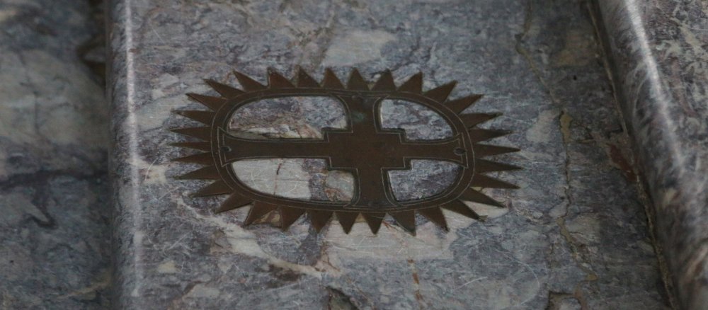 Ein Kreuz ist in eine Stufe der Heiligen Stiege in Bonn eingelassen.