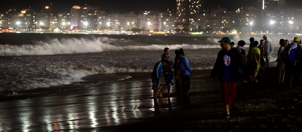 Jugendliche Pilger am Strand - im Hintergrund die erleuchtete Kulisse von Rio de Janeiro.