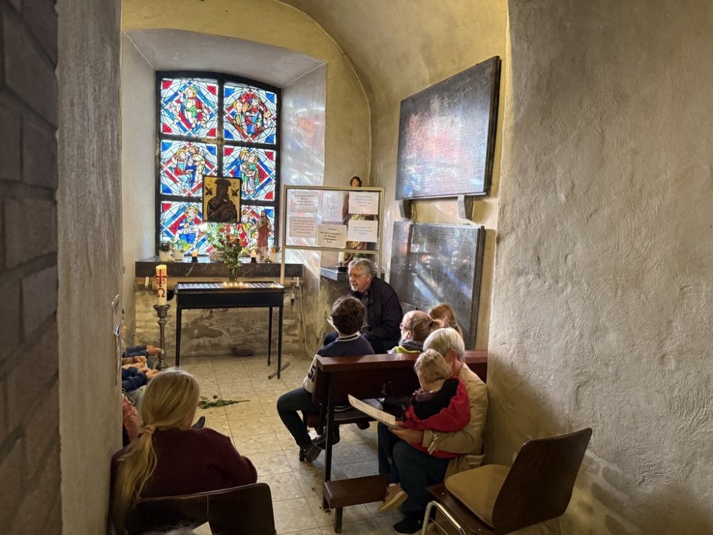 Eine Gruppe Kinder sitzt in einer Kapelle.