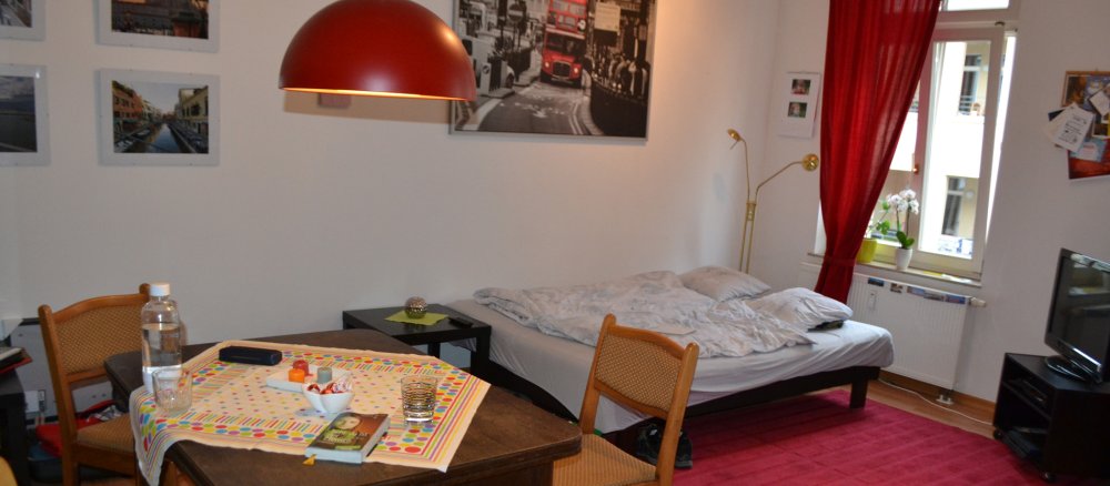 Ein Zimmer mit einem Esstisch und einem Bett.