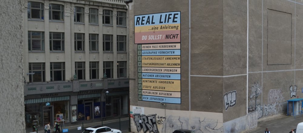 Eine Hausfassade mit einer bunten Aufschrift