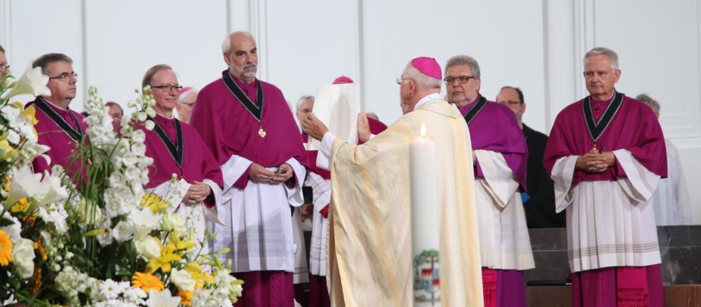 Diözesanadministrator Ulrich Boom zeigt dem Würzburger Domkapitel die Bulle des Papstes.