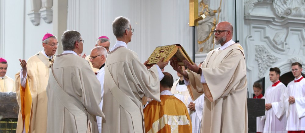 Während des Weihegebets über Franz Jung wird über dessen Haupt ein aufgeschlagenes Evangeliar gehalten.