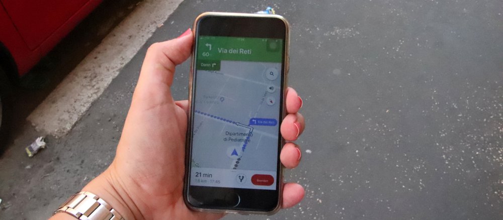 Eine Pilgerin schaut auf dem Smartphone den Wallfahrtsweg nach.