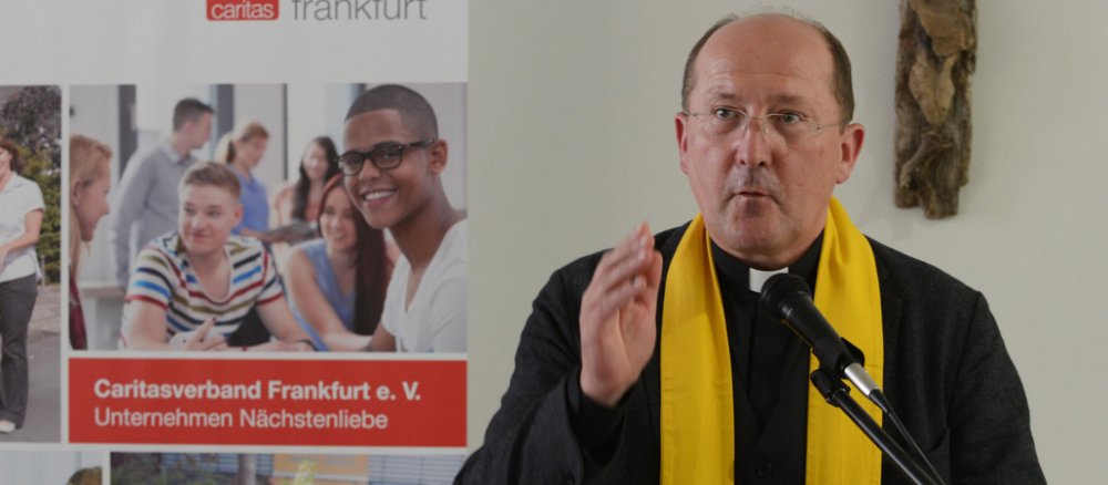 Ein Priester hebt segnend die Hand.