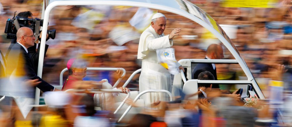 Papst Franziskus fährt mit seinem Papamobil durch eine Menschenmenge.