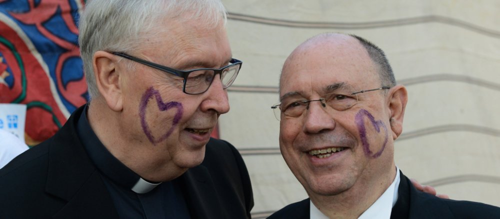 Die Gesichter von Norbert Trelle und Nikolaus Schneider - beide haben auf ihrer Wange ein großesm violettfarbenes Herz.