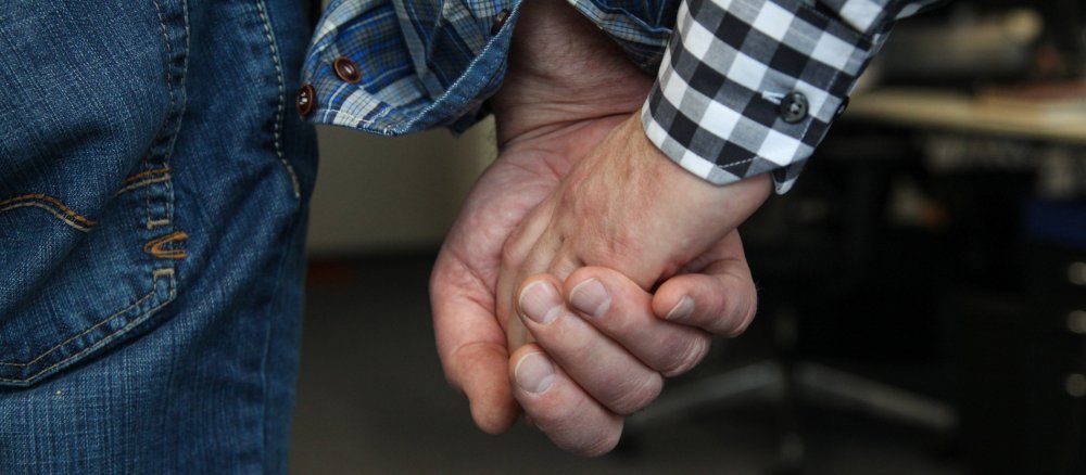 Zwei Männer halten sich an der Hand.