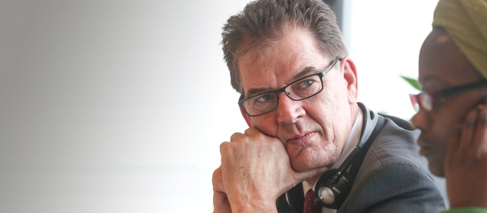 Entwicklungsminister Gerd Müller hört konzentriert einer Afrikanerin zu.