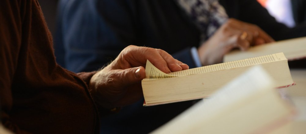 Menschen lesen bei einem Bibelkreis in der Bibel.