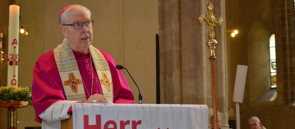 Bischof Norbert Trelle steht am Altar und predigt.