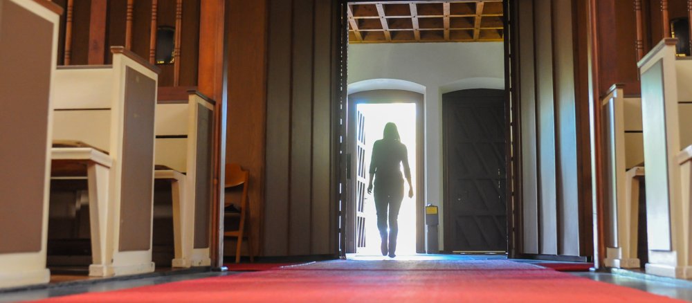 Eine Frau verlässt die Kreuzkirche in Bonn.