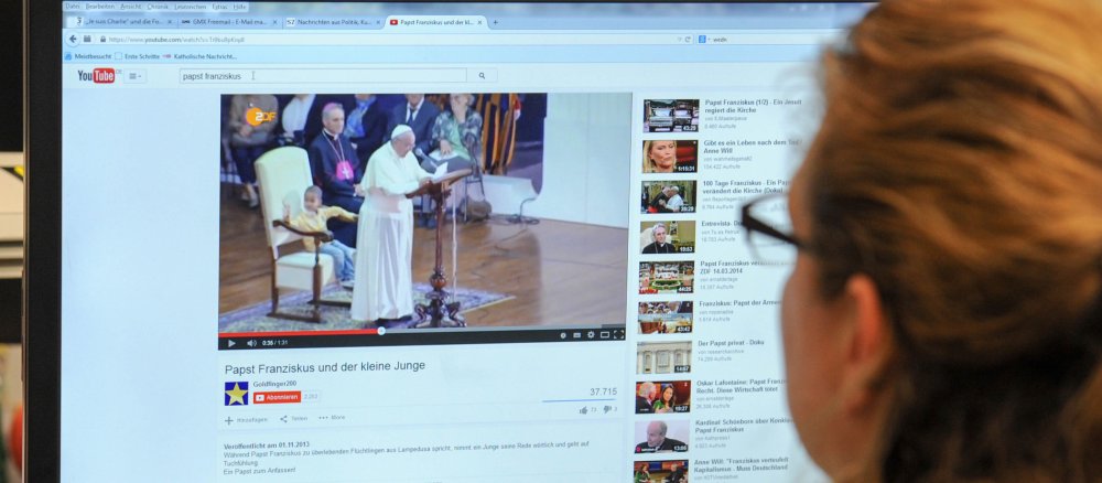 Eine Frau guckt ein YouTube-Video mit Papst Franziskus.