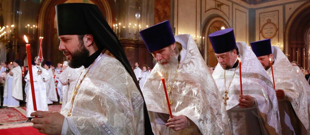 Geistliche mit Kerzen in den Händen während des festlichen Ostergottesdienstes in der Christ-Erlöser-Kathedrale am 11. April 2015 in Moskau.