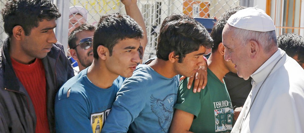Franziskus unterhält sich mit drei jungen Männern.