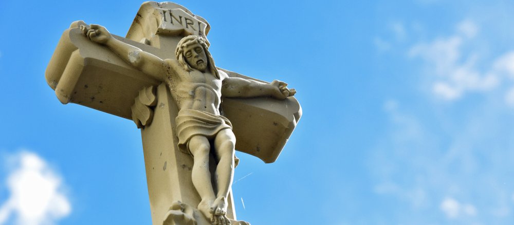 Ein Wegkreuz vor blauem Himmel.