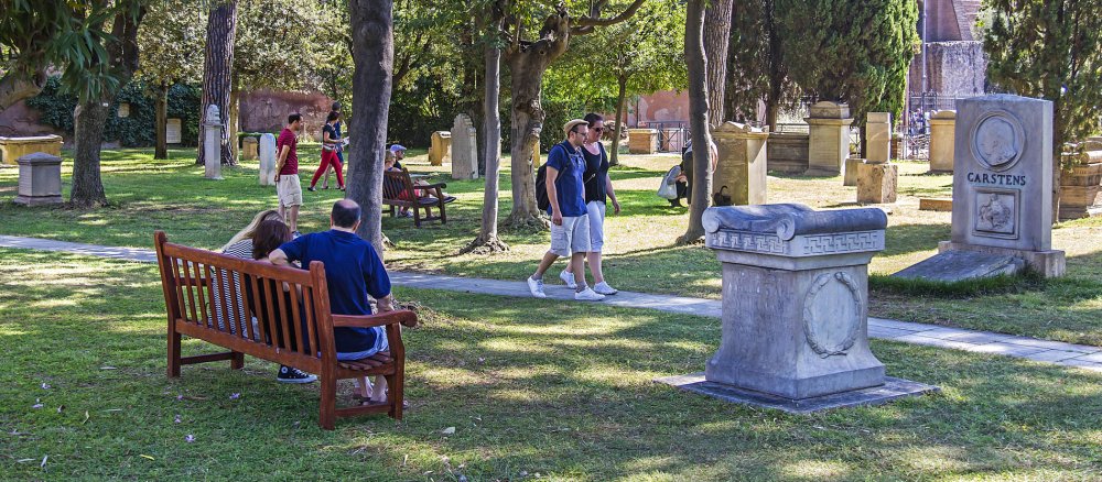 Menschen gehen auf einem Friedhof spazieren