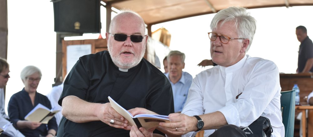 Heinrich Bedford-Strohm und Kardinal Reinhard Marx teilen sich einen Liedzettel.