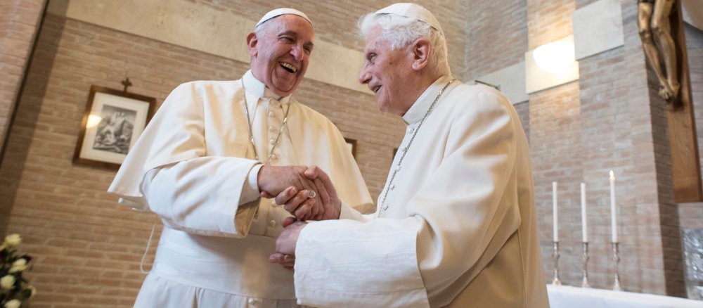 Papst Franziskus und der emeritierte Papst Benedikt XVI. schütteln sich die Hände