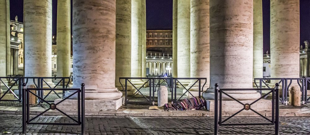 Ein Obdachloser schläft auf dem Boden unter den Bernini-Kolonnaden am Petersplatz im Vatikan.