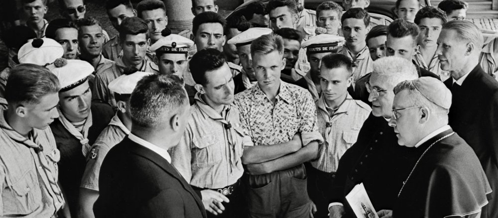 Ein schwarz-weiss-Foto zeigt einer Gruppe junger Männer und einen Bischof