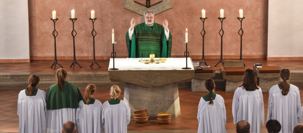 Ein Priester steht während des Hochgebets am Altar.