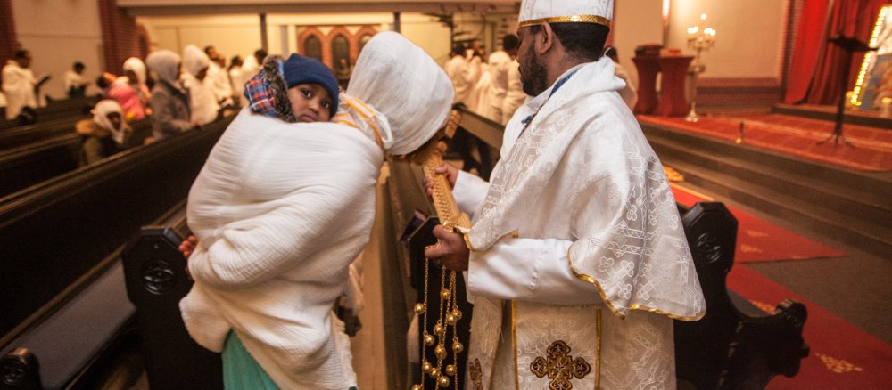 Ein Priester der eritreisch-orthodoxen Gemeinde Sankt Michael geht durch die Kirchenbänke