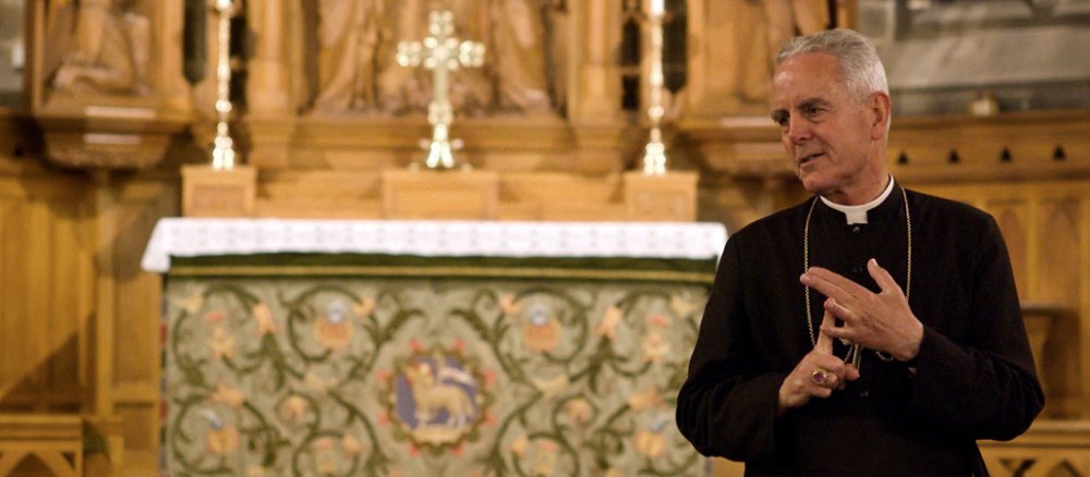 Richard Williamson steht gestikulierend von dem Altar.