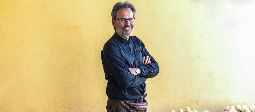 Blumendesigner Paul Deckers steht mit verschränkten Armen vor einer Wand