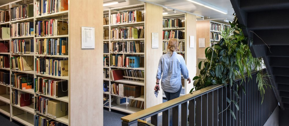 Eine Studentin geht durch die Bibliothek
