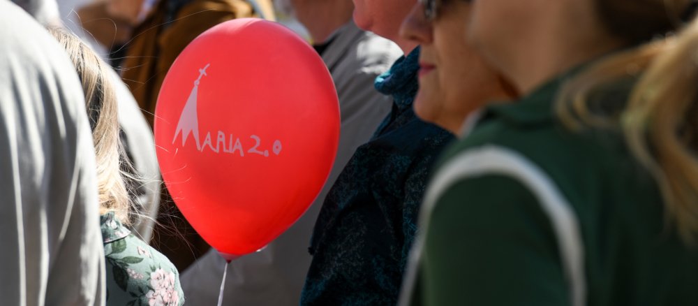 Eine Frau hält einen Luftballon mit der Aufschrift "Maria 2.0"