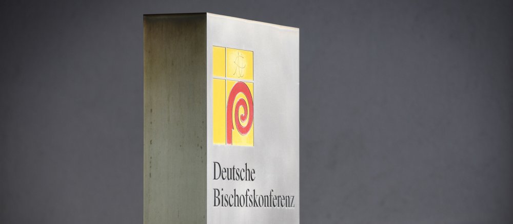 Logo der Deutschen Bischofskonferenz (DBK) auf einem Schild neben dem Eingang zum Sekretariat