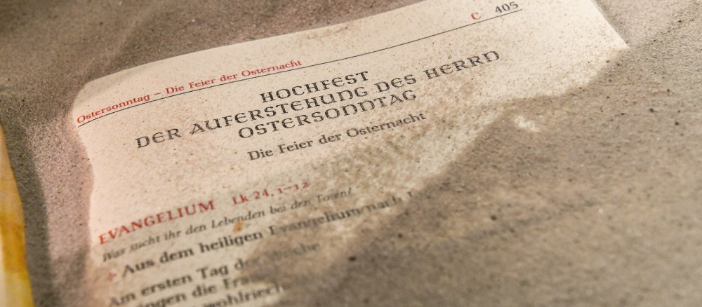 Ein Evangeliar liegt im Sand
