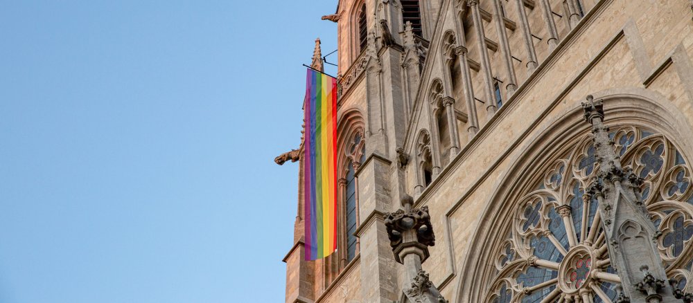 Eine Regenbogenfahne hängt am Turm der Kirche Sankt Paul in München