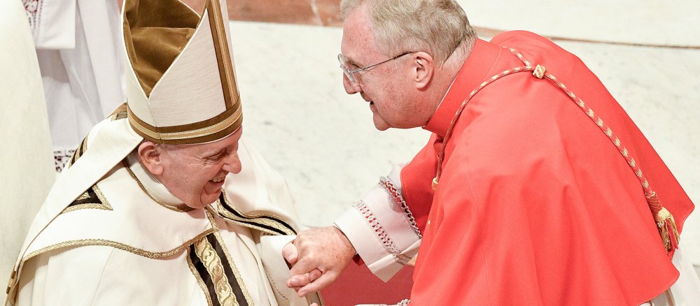 Papst Franziskus und Kardinal Arthur Roche halten sich die Hände