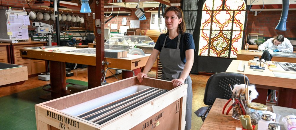 Restauratorin Élodie Schneider zieht eine Transportbox mit Glasfenstern aus der Kathedrale Notre-Dame