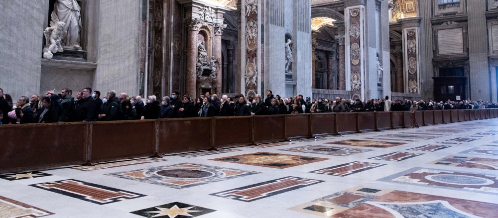 Menschen stehen in einer langen Schlange im Petersdom