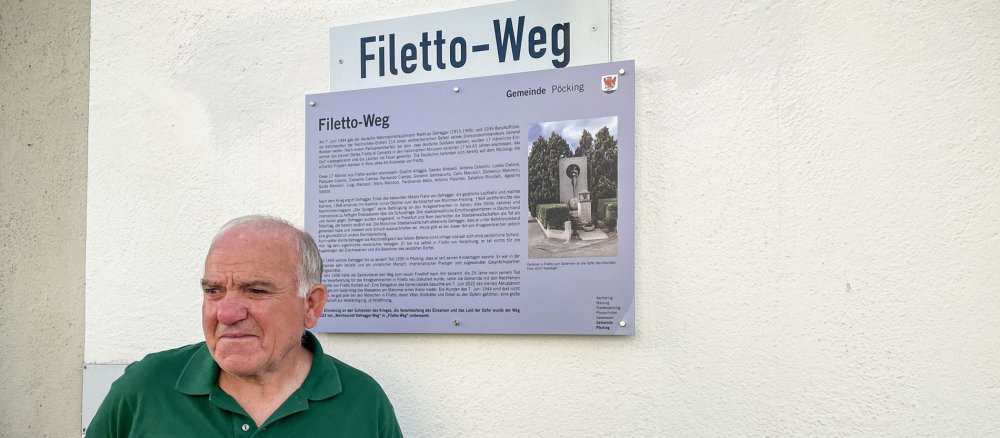 Gradito Alloggia vor dem Straßenschild "Filetto-Weg" in Pöcking