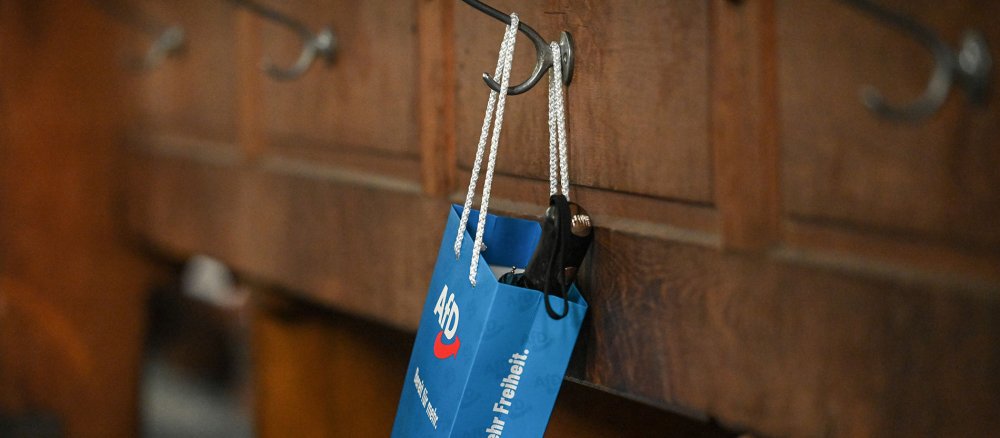 Eine Papiertasche der Partei "Alternative für Deutschland" in einer Kirchenbank.