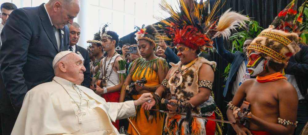 Papst Franziskus spricht mit Menschen in traditioneller Kleidung in Papua-Neuguinea