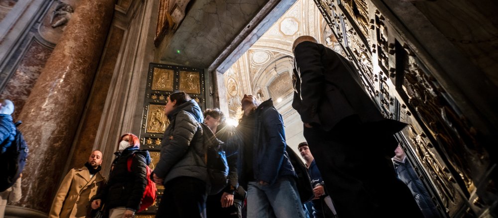Pilger durchschreiten die Heilige Pforte des Petersdoms